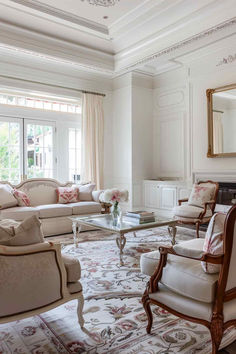 a living room filled with lots of furniture and a large mirror on the wall above it