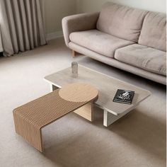 a living room with a couch, coffee table and window in the backround