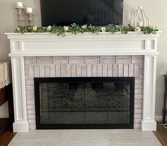 a living room with a fireplace and television on top of the mantel above it