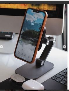 an image of a cell phone holder on a desk with a keyboard and monitor in the background