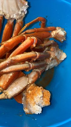 some crab legs are in a blue bowl