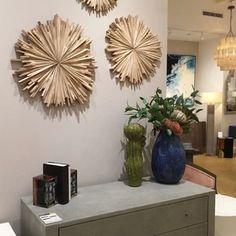 three sunbursts hanging on the wall above a dresser in a living room