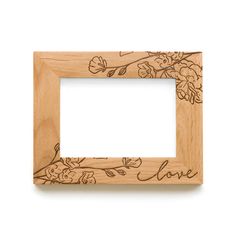 a wooden frame with flowers and leaves engraved on the front, along with a white background