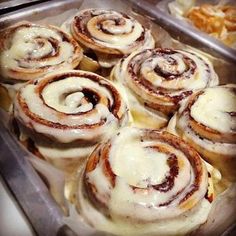 there are many cinnamon rolls on the tray