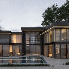 an exterior view of a modern house with pool in the foreground and large glass windows