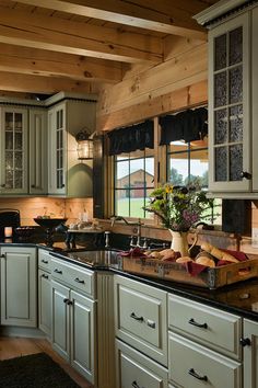 a large kitchen with white cabinets and black counter tops, along with an island in the middle