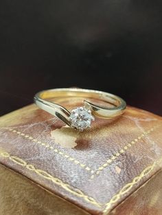 a diamond ring sitting on top of a leather case