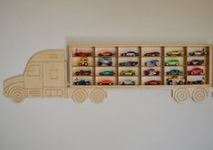 a wooden toy truck with cars on the back and shelves for it to store them