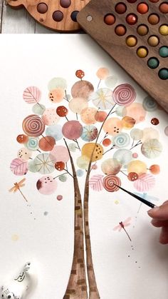 someone is painting a tree with watercolors on paper