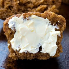 two muffins with white frosting on a table