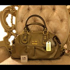 Multi-Style Coach Bronze Patent Leather Bag. It’s A Great Accent Piece To Your Wardrobe, Since It’s Bronze So It’s Not As Bright As Gold Or Silver But It Maintains A Neutral Hue. This Bag Switches Between Two Styles For One Bag. It Can Be A Cute Hand Bag Or Move The Strap From The Bottom To The Top For A Stylish Shoulder Bag. A Bit Of Marking On The Bottom Of The Bag. Designer Gold Satchel For Formal Occasions, Classic Gold Satchel With Branded Hardware, Designer Gold Satchel With Detachable Strap, High-end Gold Satchel With Gold-tone Hardware, Designer Gold Leather Bags, Designer Gold Top Handle Satchel, Gold Leather Satchel With Handles, Gold High-end Satchel For Everyday Use, High-end Gold Satchel For Everyday Use