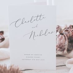 a white wedding card with the word charlotte and nicholas on it