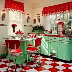 an old fashioned kitchen with red and white checkered flooring, green cabinets, and retro appliances