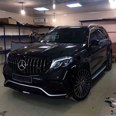 a black mercedes suv parked in a garage