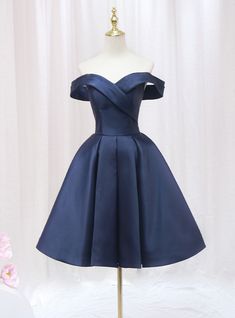 Honor your sophisticated style with this exquisite navy blue homecoming dress. The off-the-shoulder neckline creates a chic and timeless look, perfectly framing your shoulders and collarbone. The bodice is adorned with a unique wrap design that cinches at the waist, providing a flattering and comfortable fit. The full, pleated skirt adds a touch of vintage elegance, allowing for beautiful movement as you dance or walk. The rich navy satin fabric gives the dress a luxurious feel and a subtle sheen, ensuring you stand out in any crowd. This dress combines elegance and comfort, making it perfect for a night of celebration. Ideal for those who appreciate classic beauty with a modern twist, this homecoming dress will make you feel like royalty. Make a lasting impression with this stunning piece Navy Dama Dresses, Navy Blue Dama Dresses, Elegant Off-shoulder Strapless Dress For Homecoming, Elegant Blue Off Shoulder Dress For Prom Season, Elegant Off Shoulder Dress For Homecoming And Prom, Elegant Off-shoulder Dress For Prom And Homecoming, Elegant Blue Knee-length Off Shoulder Dress, Quinceanera Dama Dresses, Short Puffy Dresses