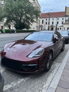 a red porsche panamera parked on the side of the road in front of some cars