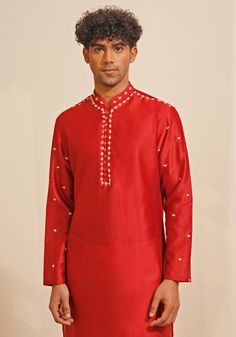 Presenting a regal Red Silk Kurta Set, featuring a Chinese collar and looped fabric buttons for a classic look. The hand-embroidered details on the neckline, shoulder, and sleeves add a touch of elegance. Paired with white pants, this ensemble is perfect for Mehendi or Sangeet events, offering a blend of traditional charm and sophisticated style. Composition : Chanderi Silk Care: Dry Clean Only and Vacuum Storage This product can be customized for sleeves, length and colour Delivery : 4-6 weeks as the product is hand crafted. Check Size Guide or choose MySize for free customisation (All Sizes above XL can be made at 15% additional cost) For more information and sizes please contact fabiliciousfashion@gmail.com or visit our Copenhagen studio. About the Designer : Shreyansh, a distinguished Traditional Sets With Embroidered Neckline For Festivities, Traditional Wedding Sets With Embroidered Neckline, Traditional Kurta With Embroidered Neckline For Diwali, Fitted Straight Kurta Set With Embroidered Neckline, Festive Kurta With Embroidered Sleeves For Festivals, Festive Designer Traditional Wear With Embroidered Neckline, Fitted Kurta With Set-in Sleeves For Festive Occasions, Traditional Sets With Embroidered Neckline For Diwali, Traditional Set With Embroidered Neckline For Diwali