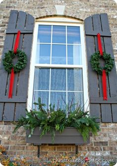 the window is decorated with wreaths and red ribbons