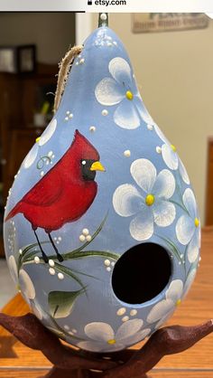 a painted birdhouse with a cardinal on it