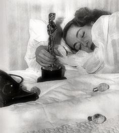 a woman laying in bed next to an award