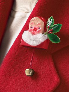 a close up of a person wearing a red coat with a christmas decoration on it