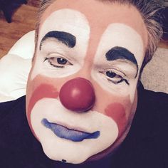 a man with his face painted to look like it is wearing a clown's nose