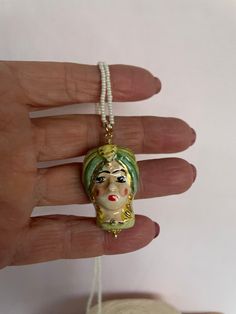 ✔️Delicate necklace with a very Sicilian style! It is made with a string of river micropearls, and as a pendant it has a Moor's Head, both male and female, in Caltagirone ceramic, hand painted and in shades of green. The closure is a gold-plated stainless steel lobster clasp. This necklace in its sobriety has a lot of character and is an example of great craftsmanship. Perfect jewel to enrich a casual outfit! Choose whether you want the male or female figure or both! ✔️DETAILS: 🟩 Materials: Riv Green Pearl Necklace For Gift, Sicilian Style, Unisex Necklace, Green Colour, Delicate Necklace, Outfit Casual, Artisan Jewelry, Shades Of Green, Green Colors