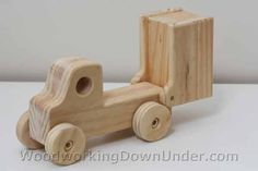 a wooden toy truck is shown on a white surface