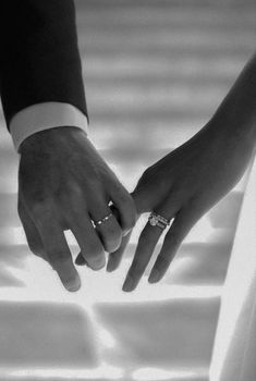 two people holding hands with their wedding rings