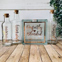 three personalized glass bottles sitting on top of a wooden table