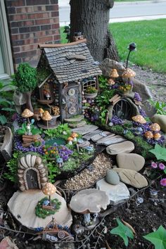 a fairy garden is shown in front of a tree