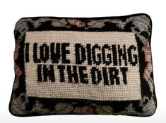 a pillow that says i love digging in the dirt with black and white flowers on it