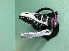 a dinosaur skull with headphones mounted on a wall