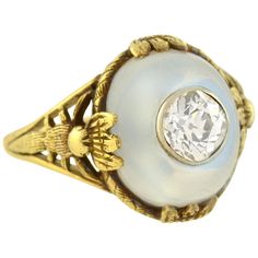 An incredible moonstone and diamond ring from the Art Nouveau (ca1900) era! Crafted in 14kt yellow gold, this fantastic and unusual piece has an artistic wirework setting which holds a large moonstone cabochon at its center. The oval shaped moonstone is prong set and displays gorgeous pale blue color with an iridescent flash and a lovely translucent quality and riveted into the center is an old Mine Cut diamond which weighs approximately 0.80ct. The diamond is bezel set in white gold and surroun Dragonfly Motif, Diamond Jewlery, Pale Blue Color, Art Nouveau Ring, Opal Ring Gold, Gold Signet Ring, Art Nouveau Jewelry, Wide Band Rings, Domed Ring