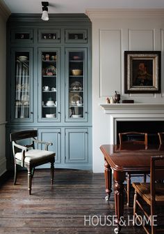 a dining room with blue cabinets and wooden floors