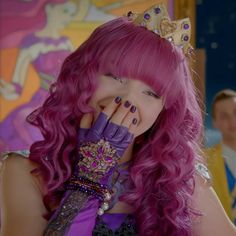 a woman with pink hair and purple gloves covering her face while wearing a tiara