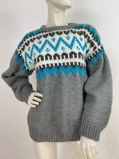 a mannequin wearing a gray and blue sweater