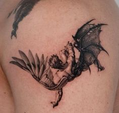 a black and white photo of a dragon on the back of a woman's shoulder