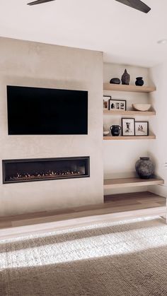 a living room with a flat screen tv mounted on the wall next to a fireplace