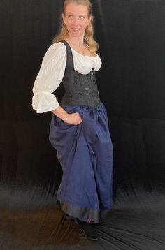 This pretty skirt is an easy staple for your Renaissance Faire wardrobe.  Made of rich, dark blue cotton, it also boasts a wide black ribbon trim, which looks pretty and helps the skirt to fall nicely around the hem.  Airy cotton helps keep you cooler than stuffy synthetics on hot days.  Drawstring waist adjusts to fit most. Full 110" sweep fits over a modest hooped petticoat if desired.  Pair it with a saucy black corset. and you are ready for the Faire! Length: 39" Navy Cotton Lined Skirt, Navy Cotton Skirt, Linen Gown, Edwardian Corsets, Colonial Dress, Pretty Skirt, Ren Fest, Pretty Skirts, Black Corset