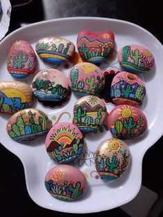 painted rocks in the shape of cactus on a plate