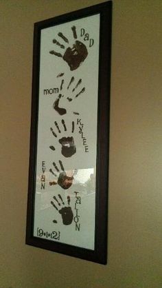 a framed photo with handprints on the wall above it that says, dad