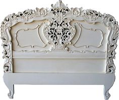 a white bed with ornate carvings on the headboard and foot board, against a white background