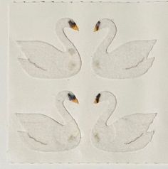 three white swans are in the middle of a square pattern on a piece of paper