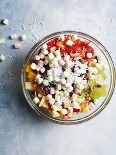 a glass bowl filled with fruit and marshmallows