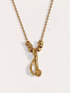 a gold necklace with two charms hanging from it's sides, on a white background