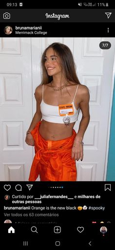 a woman in an orange skirt and white top posing for the camera with her hands on her hips