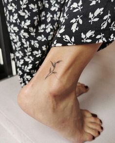 a woman's foot with a small flower tattoo on her left side calfocks