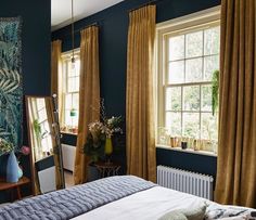 a bedroom with blue walls and gold curtains