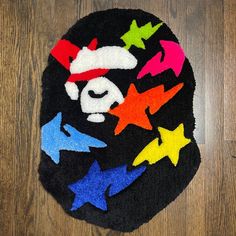 a black rug with multicolored stars and a bear's face on it